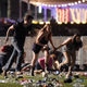 People run from the Route 91 Harvest country music festival after apparent gun fire was hear on October 1, 2017 in Las Vegas, Nevada.(Photo by David Becker/Getty Images)
